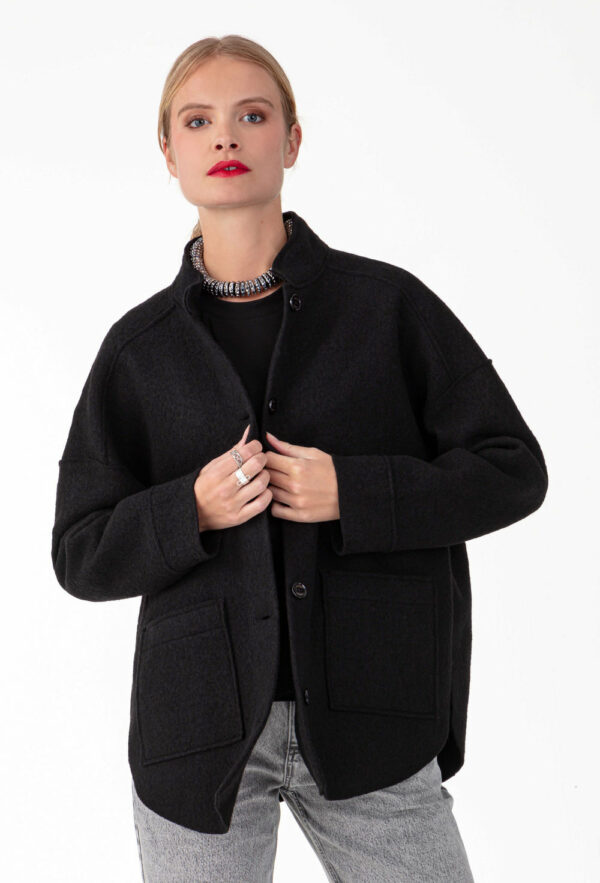 Surchemise noire en laine Réalisée en laine bouillie , elle affiche des emmanchures basses et des bords nets. Intégrer de 2 poches carrées sur le devant, parfait pour y ranger vos indispensables. Les boutons noirs sur le devant sont la touche sportwear chic de la pièce.