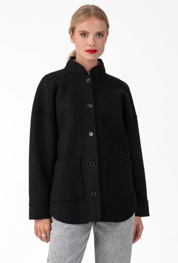 Surchemise noire en laine Réalisée en laine bouillie , elle affiche des emmanchures basses et des bords nets. Intégrer de 2 poches carrées sur le devant, parfait pour y ranger vos indispensables. Les boutons noirs sur le devant sont la touche sportwear chic de la pièce.