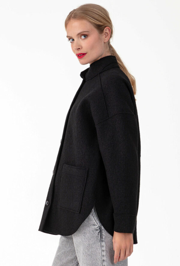 Surchemise noire en laine Réalisée en laine bouillie , elle affiche des emmanchures basses et des bords nets. Intégrer de 2 poches carrées sur le devant, parfait pour y ranger vos indispensables. Les boutons noirs sur le devant sont la touche sportwear chic de la pièce.
