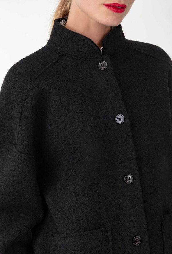 Surchemise noire en laine Réalisée en laine bouillie , elle affiche des emmanchures basses et des bords nets. Intégrer de 2 poches carrées sur le devant, parfait pour y ranger vos indispensables. Les boutons noirs sur le devant sont la touche sportwear chic de la pièce.