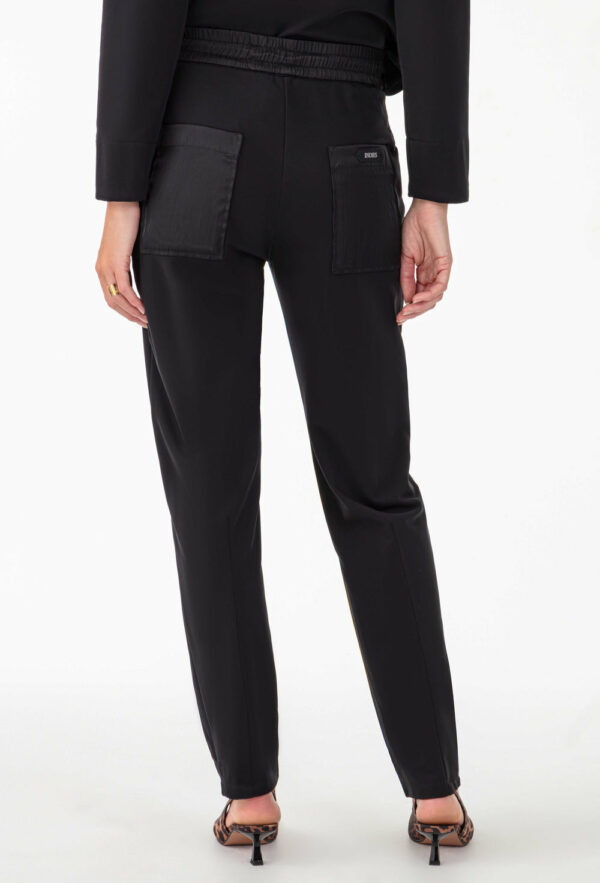 - Joggpant en jersey technique gratté et nylon crinkle, alliant confort et style - Poche carpentier fonctionnelle pour un look utilitaire tendance - Fourreau ceinture pour une finition soignée - Poche plaquée dos en nylon crinkle pour un contraste de matière - Taille ajustable par cordon élastiqué à effet laineux et stopper en métal argenté